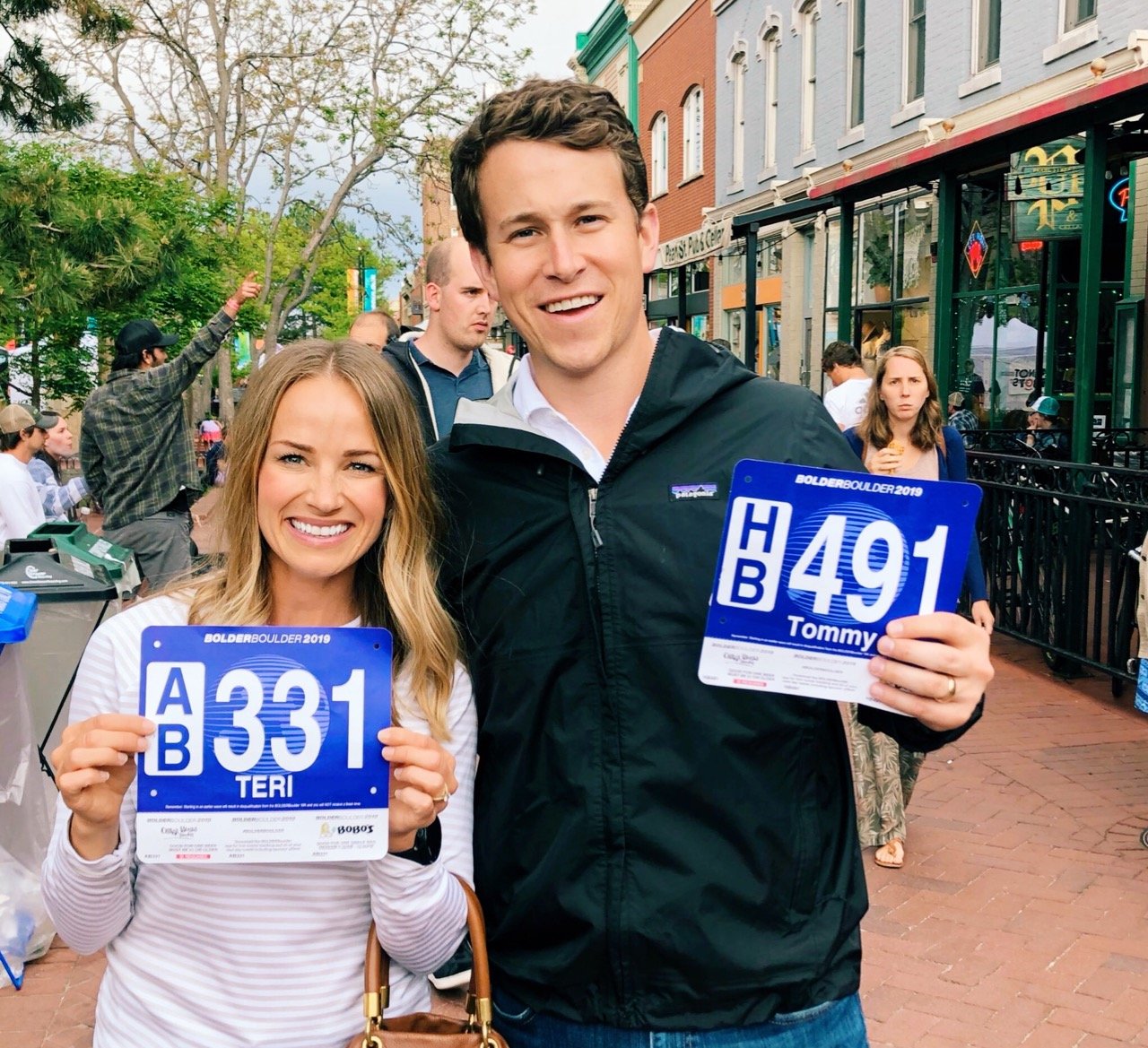 man and woman holding race bibs