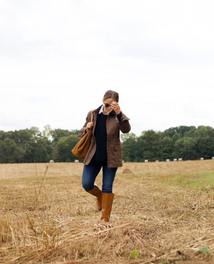 Woman walking in field wearing fall outfit