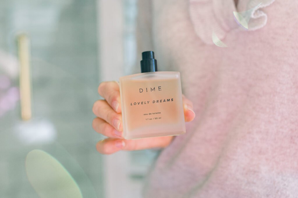 Woman holding DIME perfume