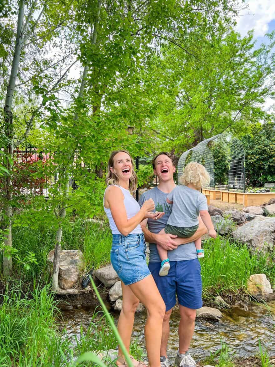 Woman wearing Valerie Cutaway-Neck Racerback Rib Knit Tank Top at the creek with family