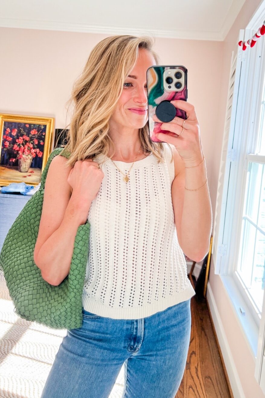 woman taking a selfie and holding a green purse