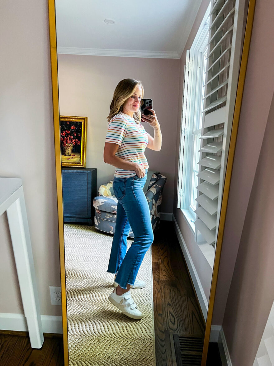 woman showing the details of her Striped Tee and Blue Jeans