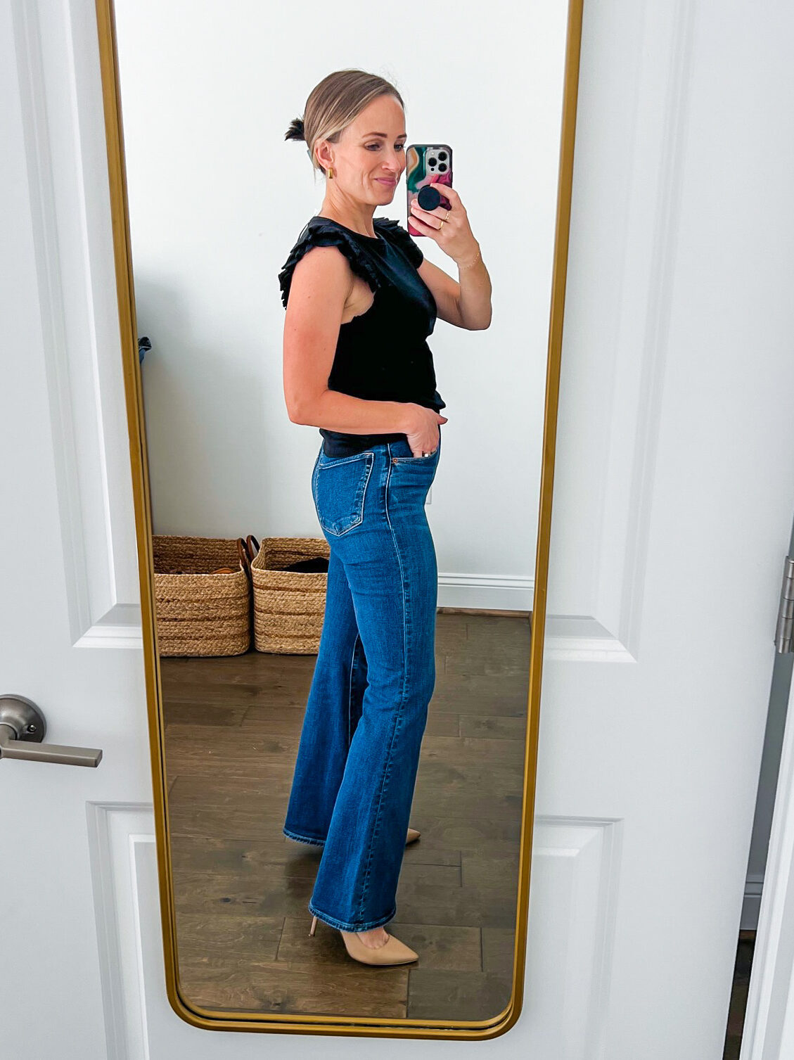 TeriLyn Adams showing the side details of one of the Best Abercrombie Jeans in Ultra High Rise Flare Jean in black and dark blue wash