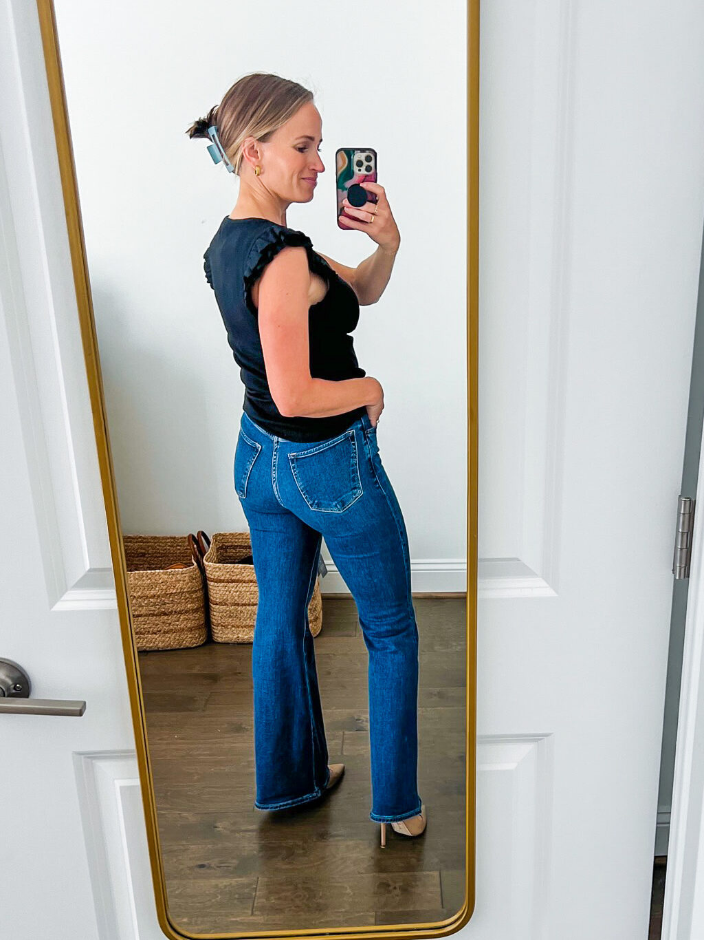 TeriLyn Adams showing the back details of one of the Best Abercrombie Jeans in Ultra High Rise Flare Jean in black and dark blue wash