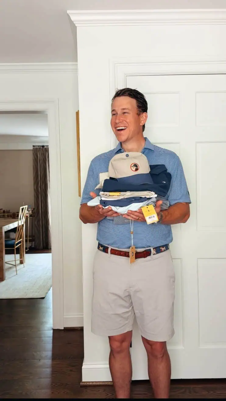 Man wearing Duck Head and holding a stack of Duck Head clothes