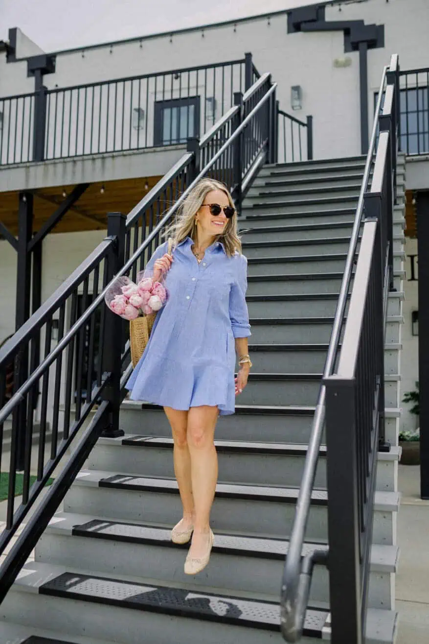 Woman walking down stairs wearing one of the best Tuckernuck dresses: Chambray Callahan Shirt Dress