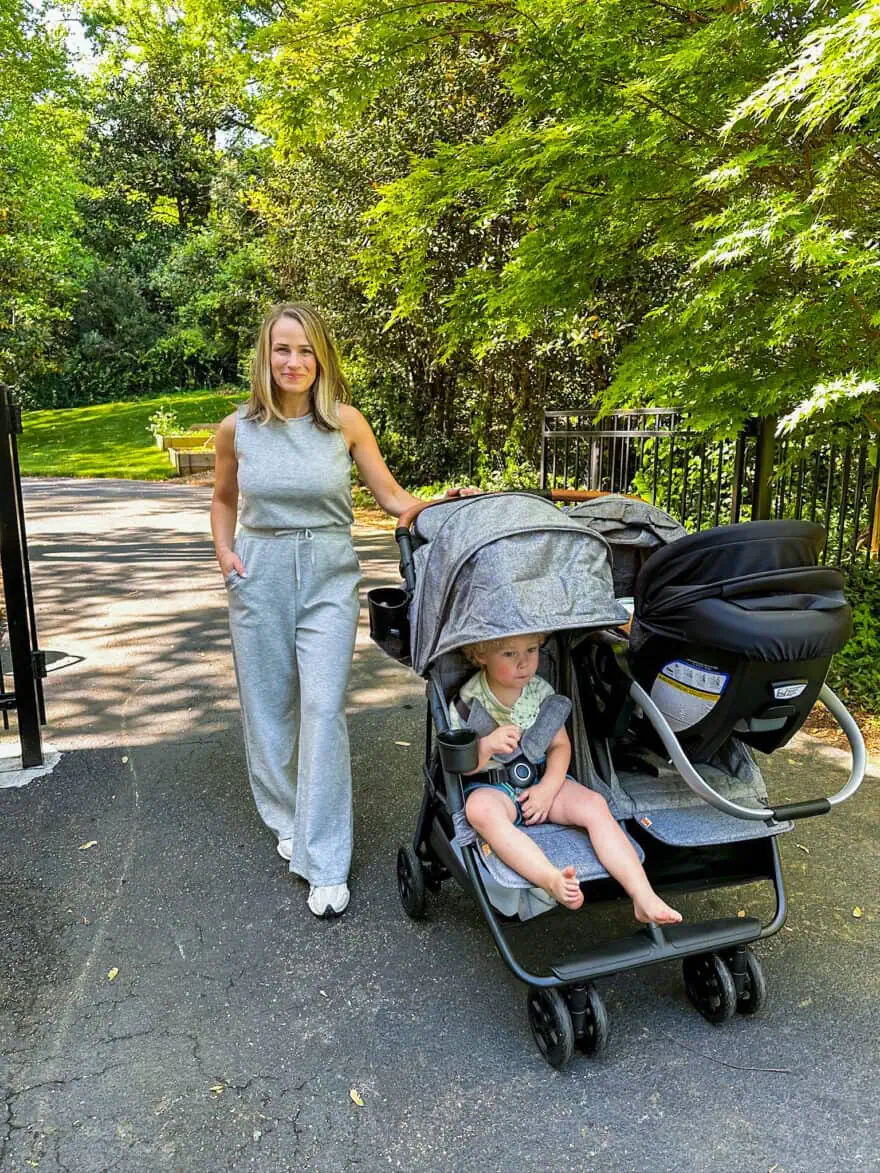 Woman standing with sons sitting in Zoe stroller