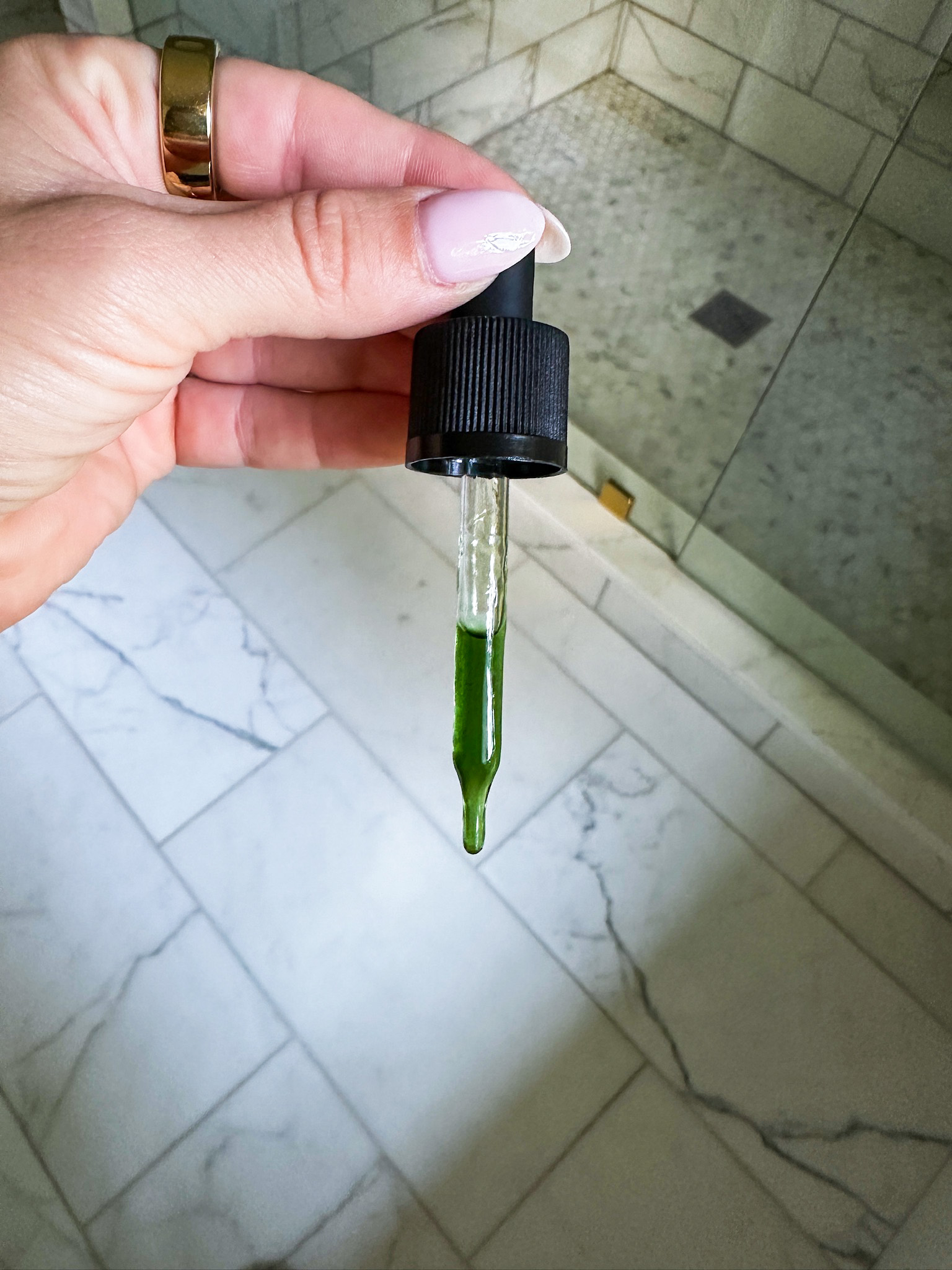 Oliveda AHA serum in the dropper showing that it's green