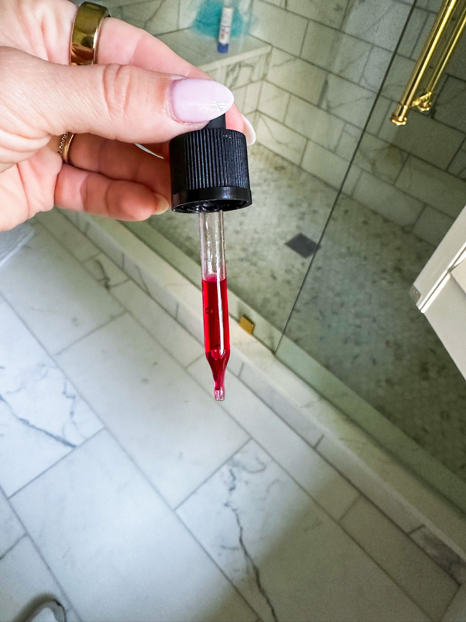 Oliveda's HT+Vitamin C Serum in a Dropper showing it's red