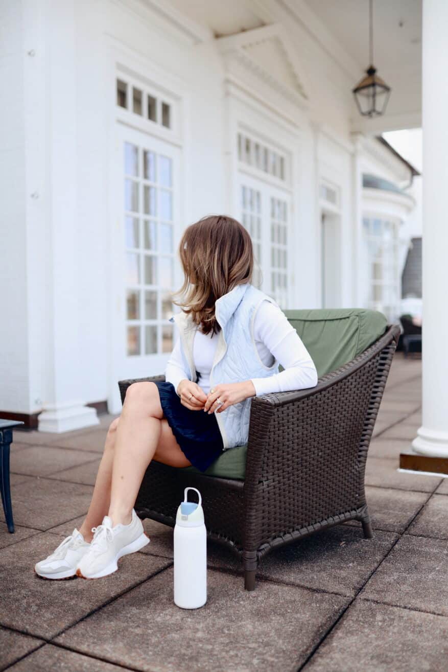 Woman wearing sneakers with athleisure skort and vest