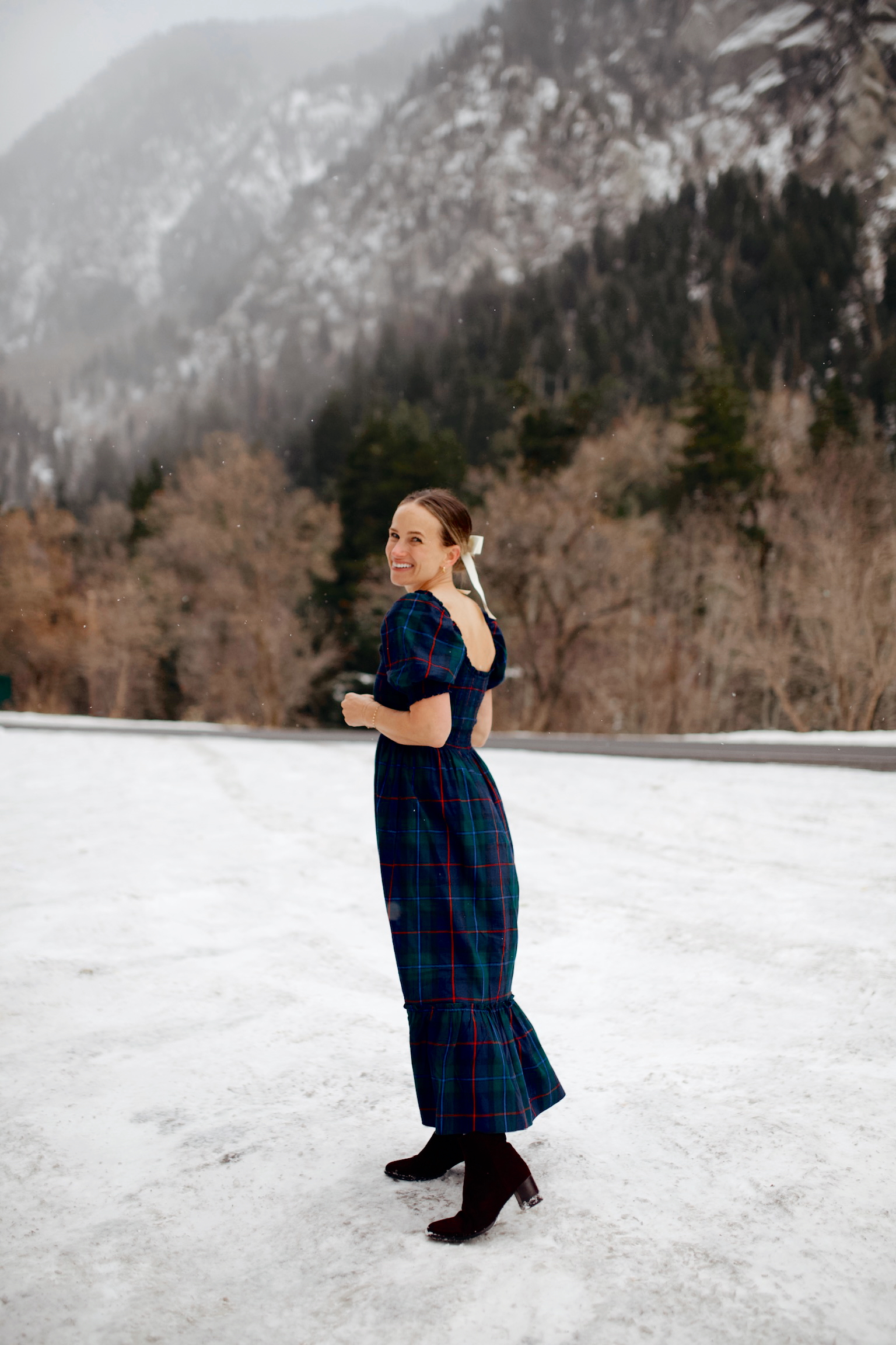 Woman walking in snow with long dress and ankle boots