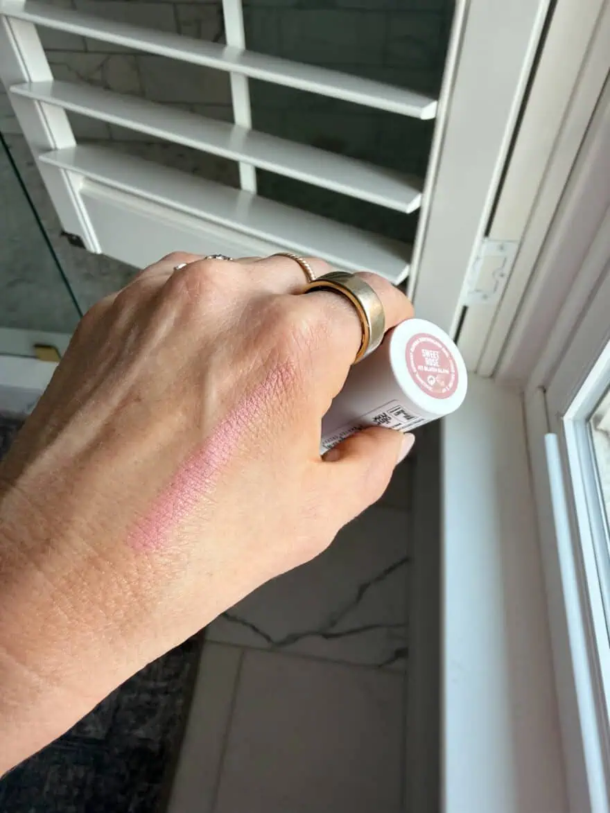 Woman showing HT Blush Glow on skin