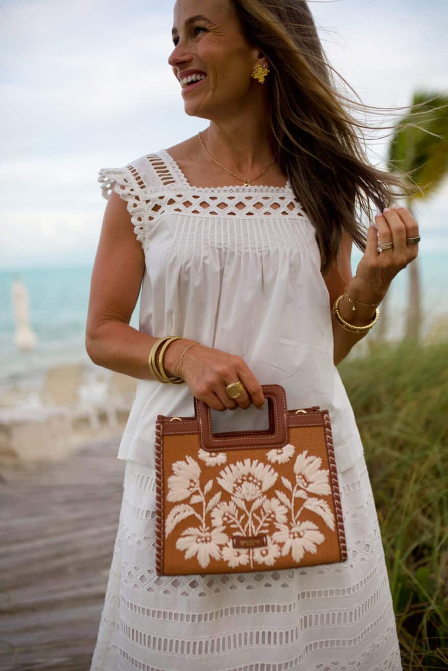 Woman wearing matching eyelet set with leather purse