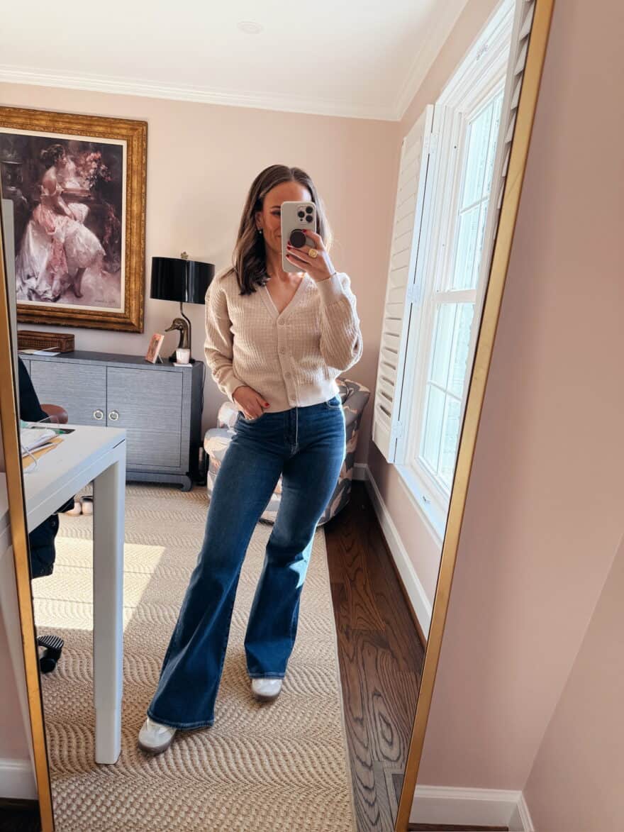 Woman pairing fashion sneakers with ankle-length flare jeans