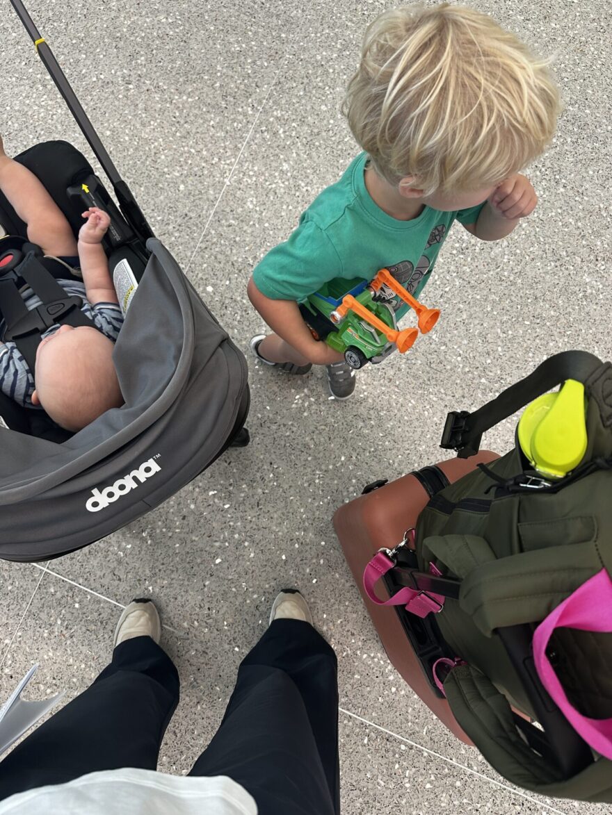 Doona car seat clipped into stroller frame in toy store aisle