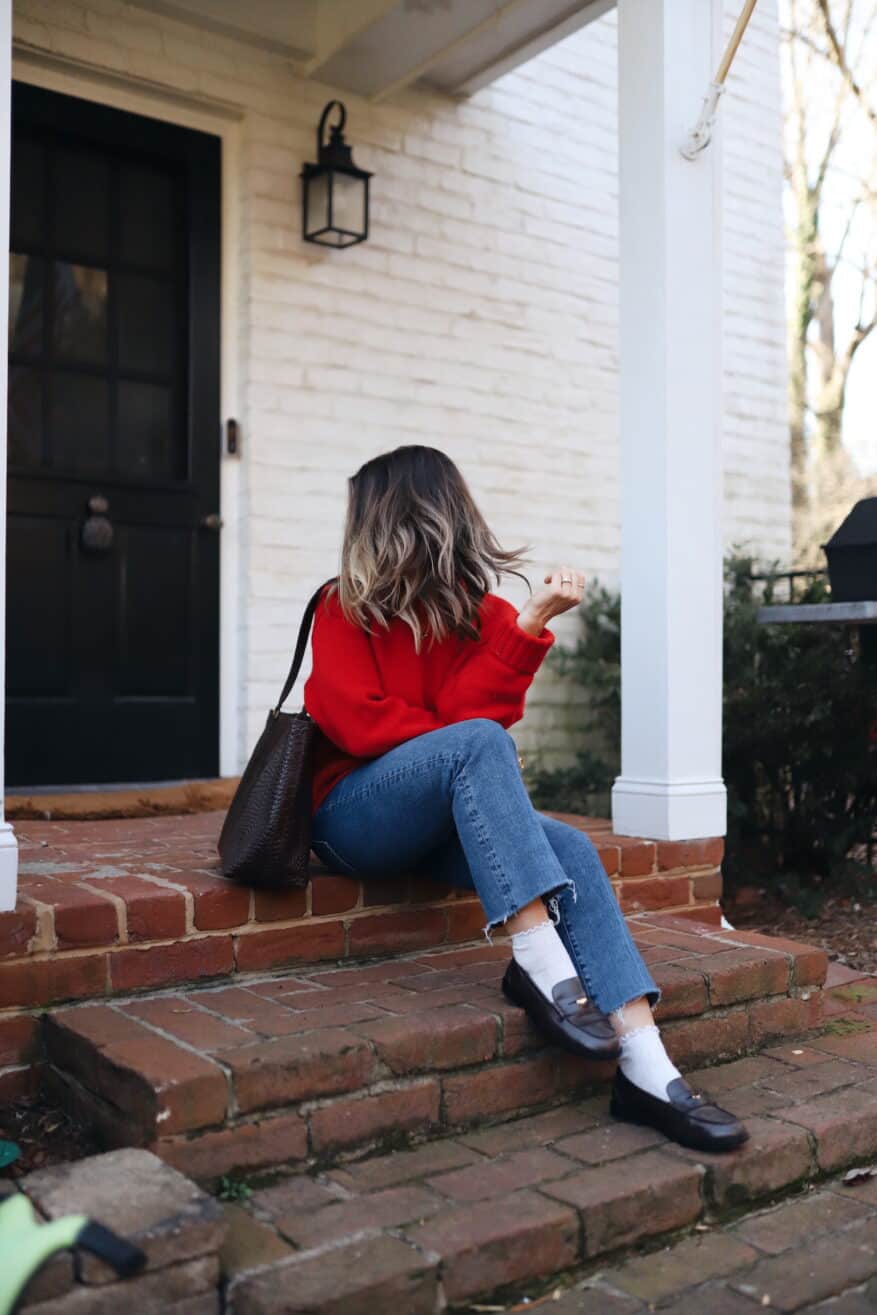 Woman wearing loafers and ruffled socks with denim