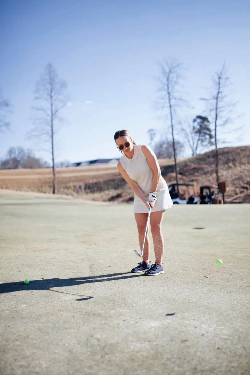 Woman playing golf in A. Putnam C'est Tout Skort