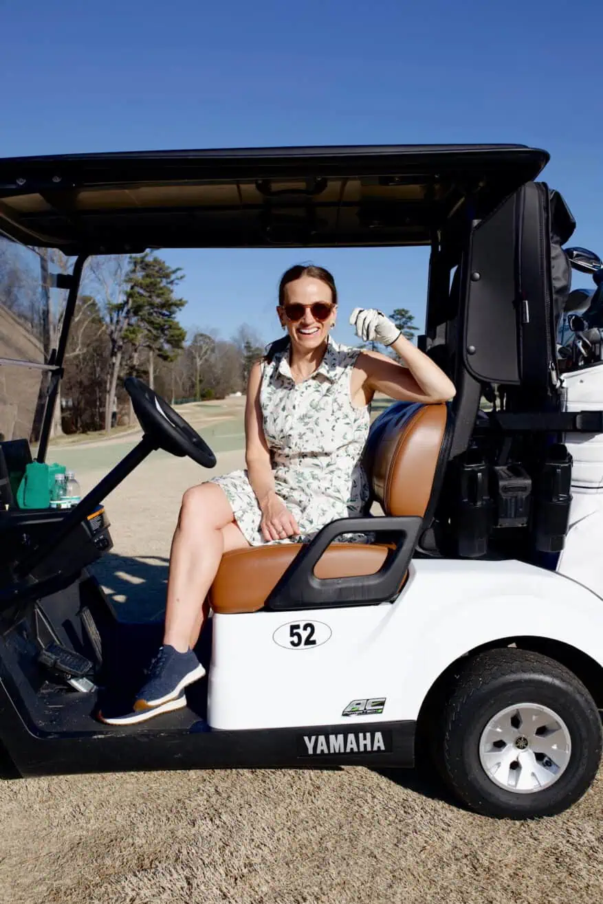 Woman wearing a cute golf outfit on a golf cart