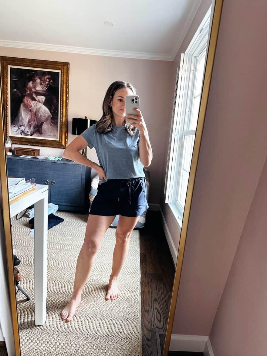 Woman wearing Quince active shorts with light blue top