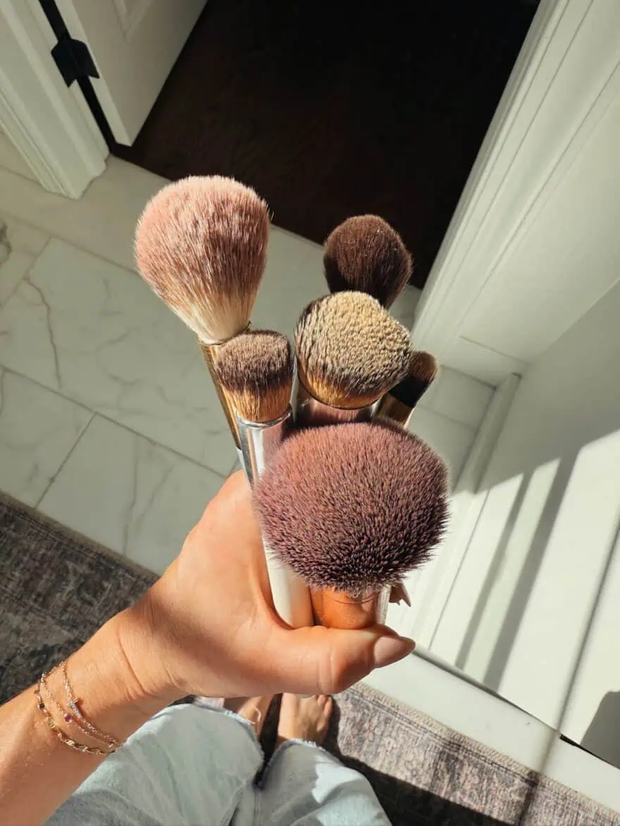 Woman showing brushes with make-up on them
