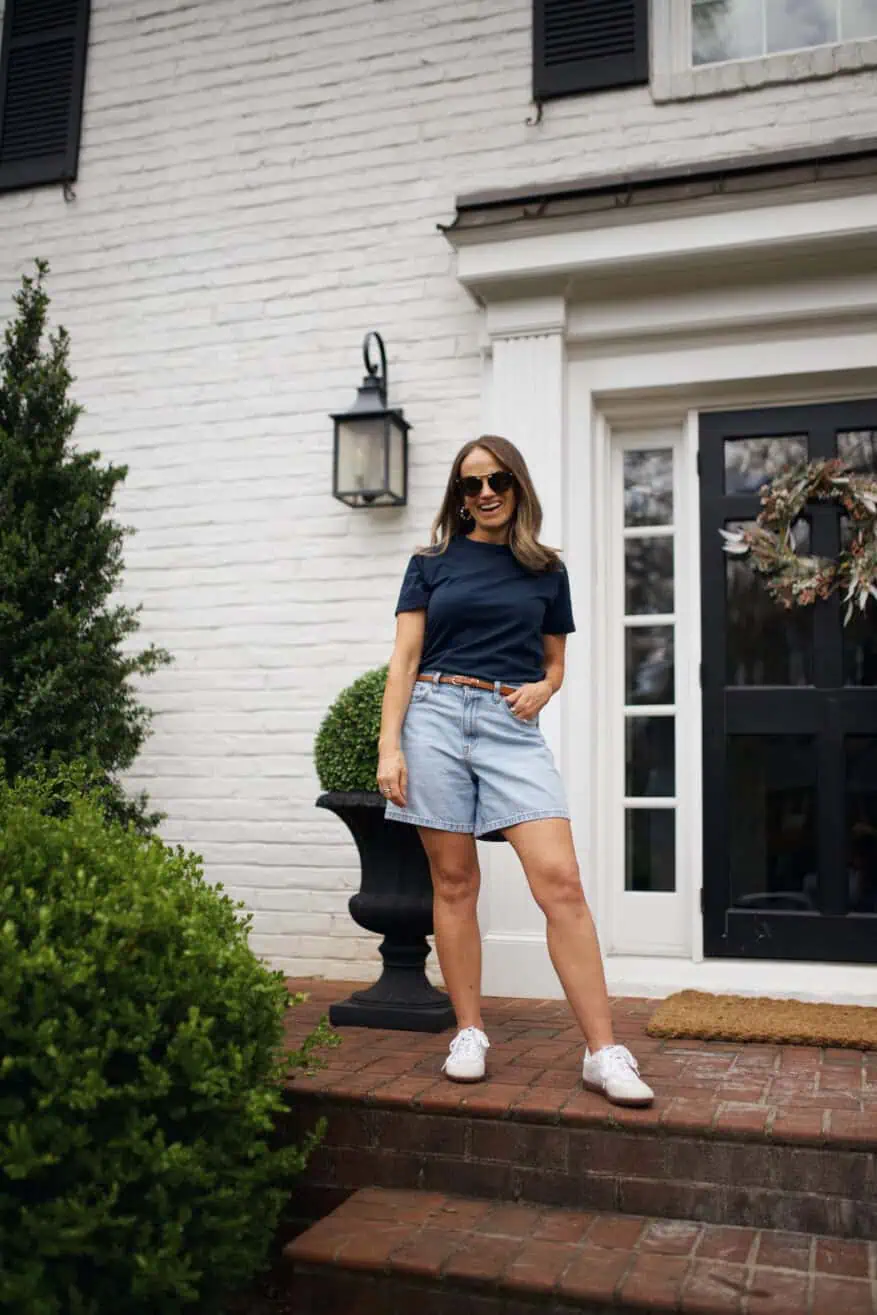 Woman wearing Abercrombie denim shorts with blue t-shirt and white sneakers and sunglasses