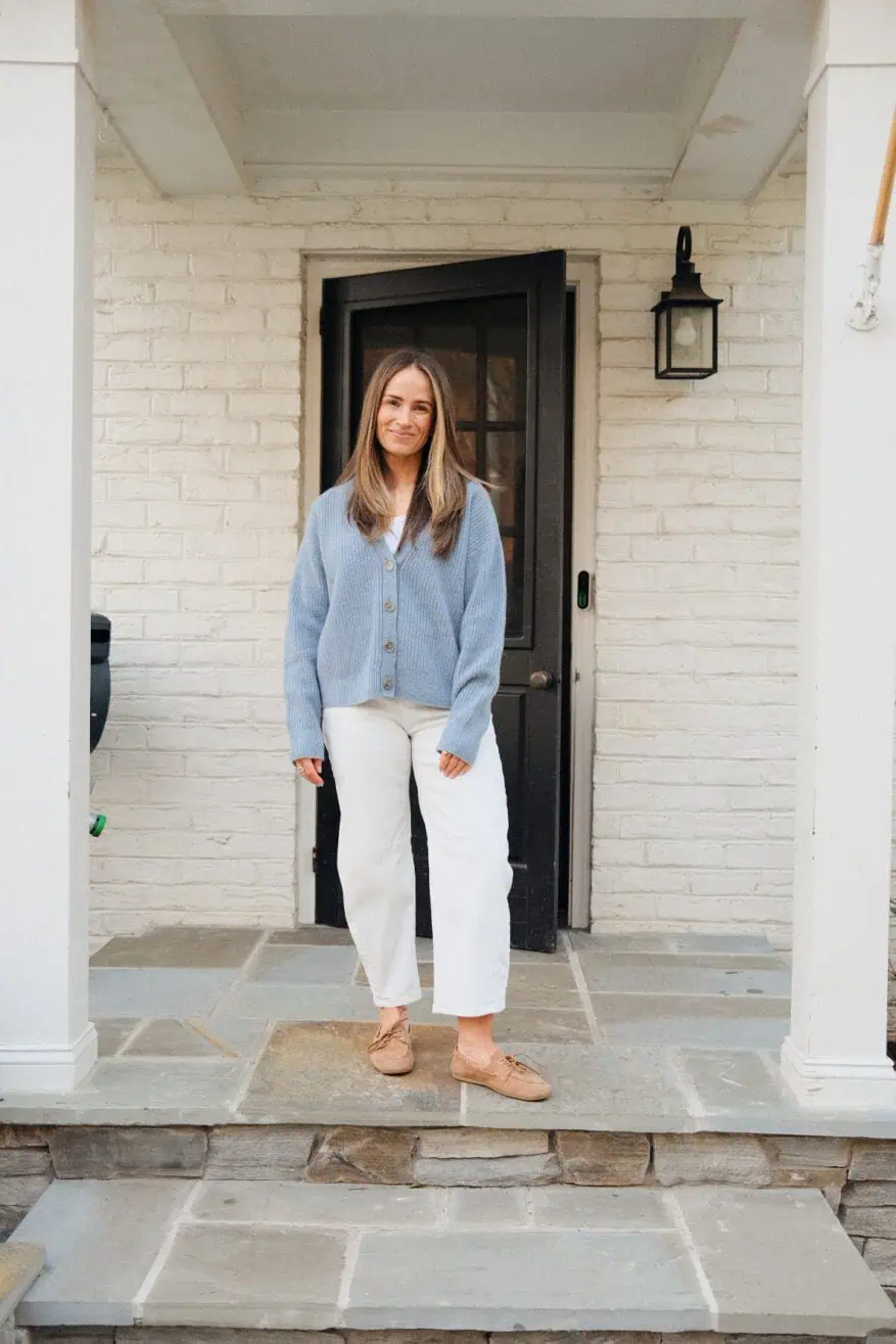 Woman wearing white barrel jeans with blue sweater