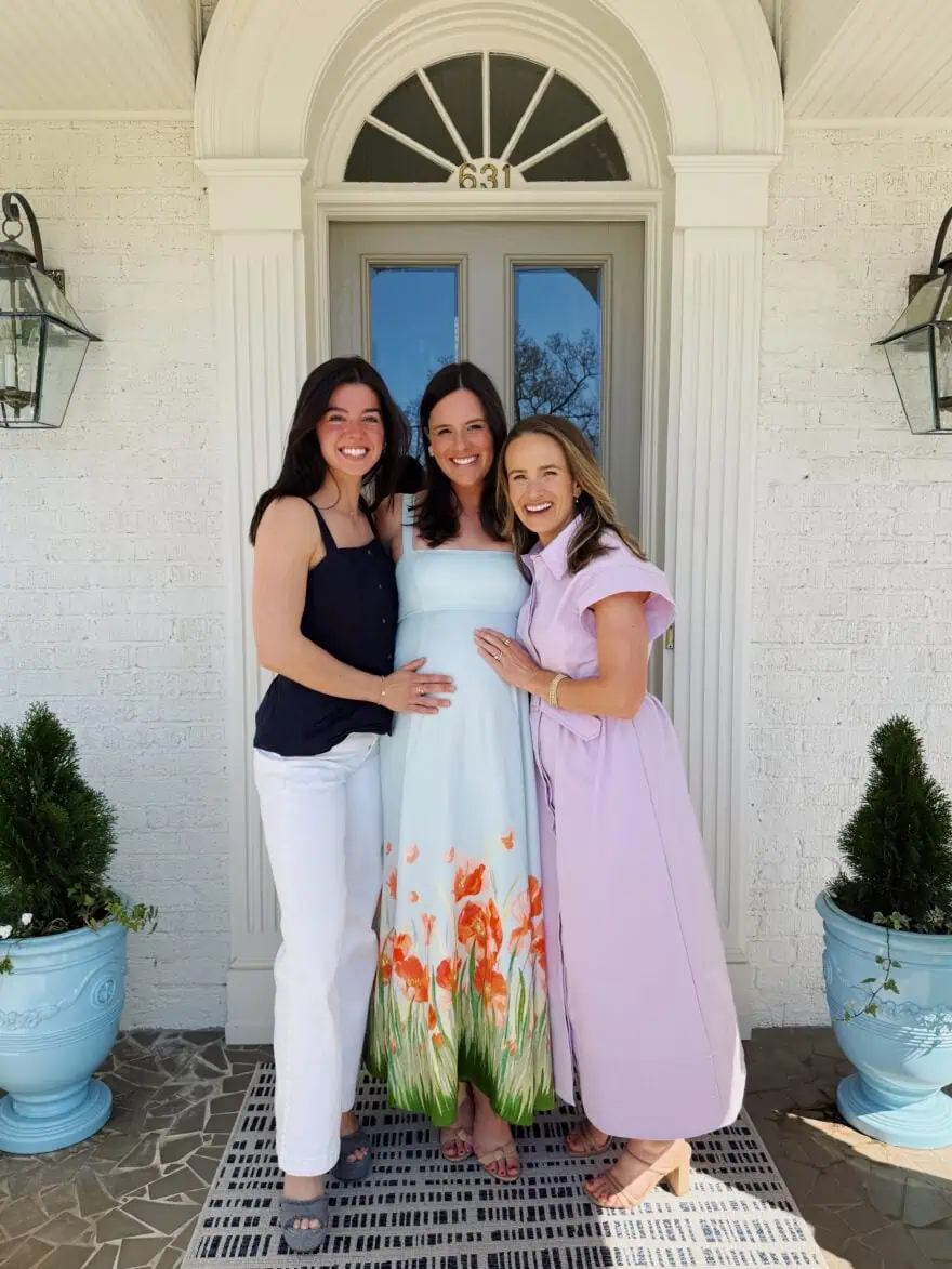 Woman at a baby shower posing with pregnant mom-to-be