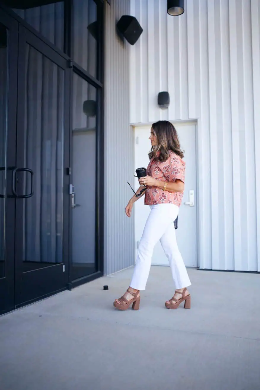 Woman walking into church wearing white denim and a blouse