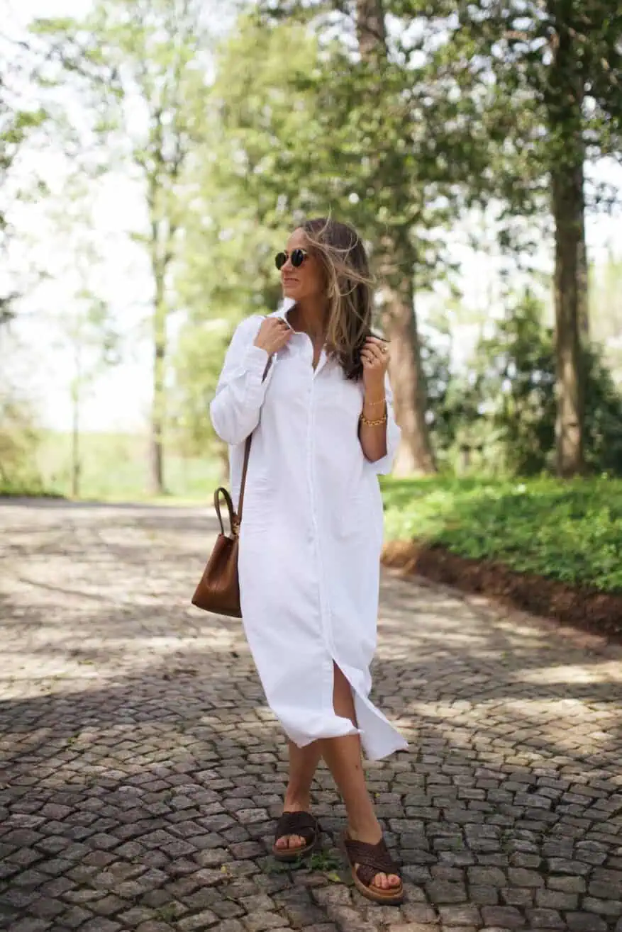 Woman walking in white linen dress and brown sandals