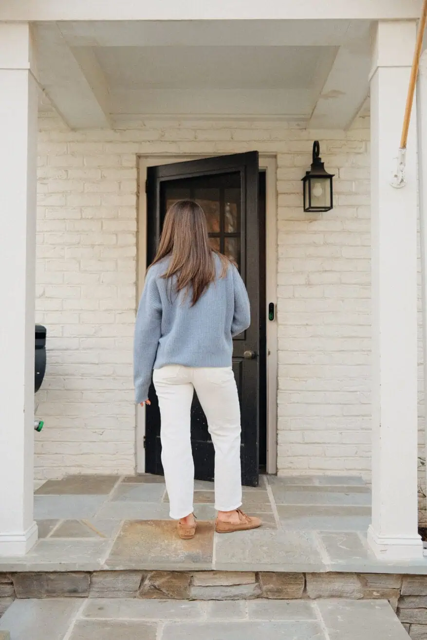 Woman wearing Madewell straight jeans in white white blue sweater