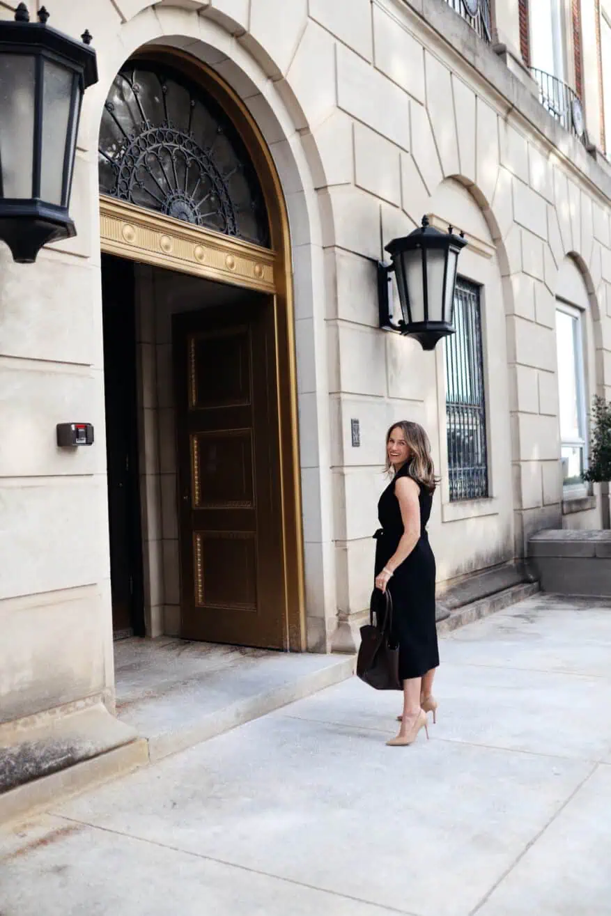 Woman wearing a black dress and Sam Edelman Hazel Pump with black handbag