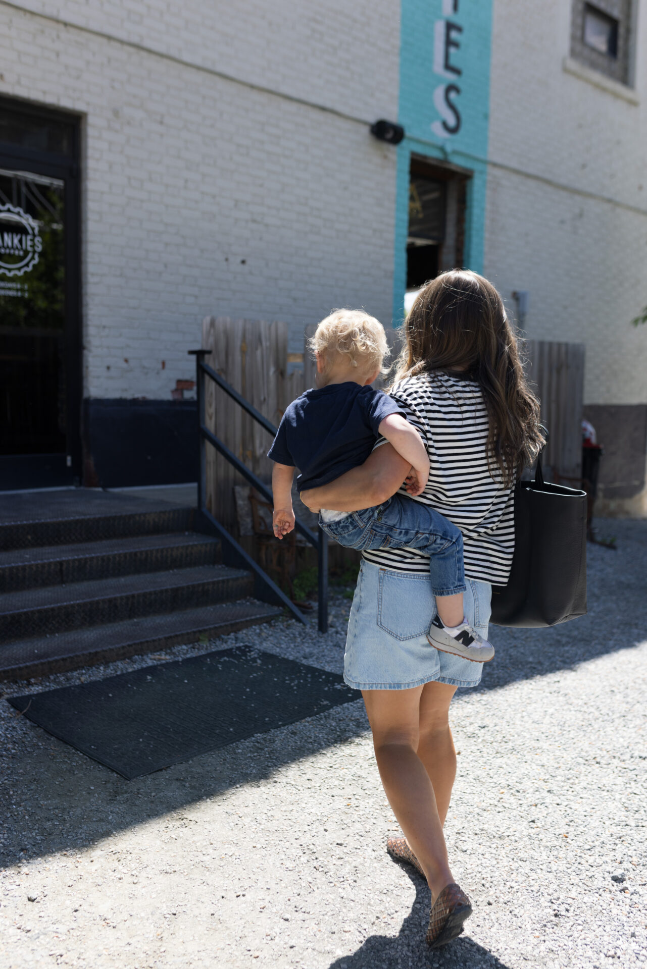 TeriLyn Adams holding toddler wearing Abercrombie lose shorts and stripe tee with jelly shoes.