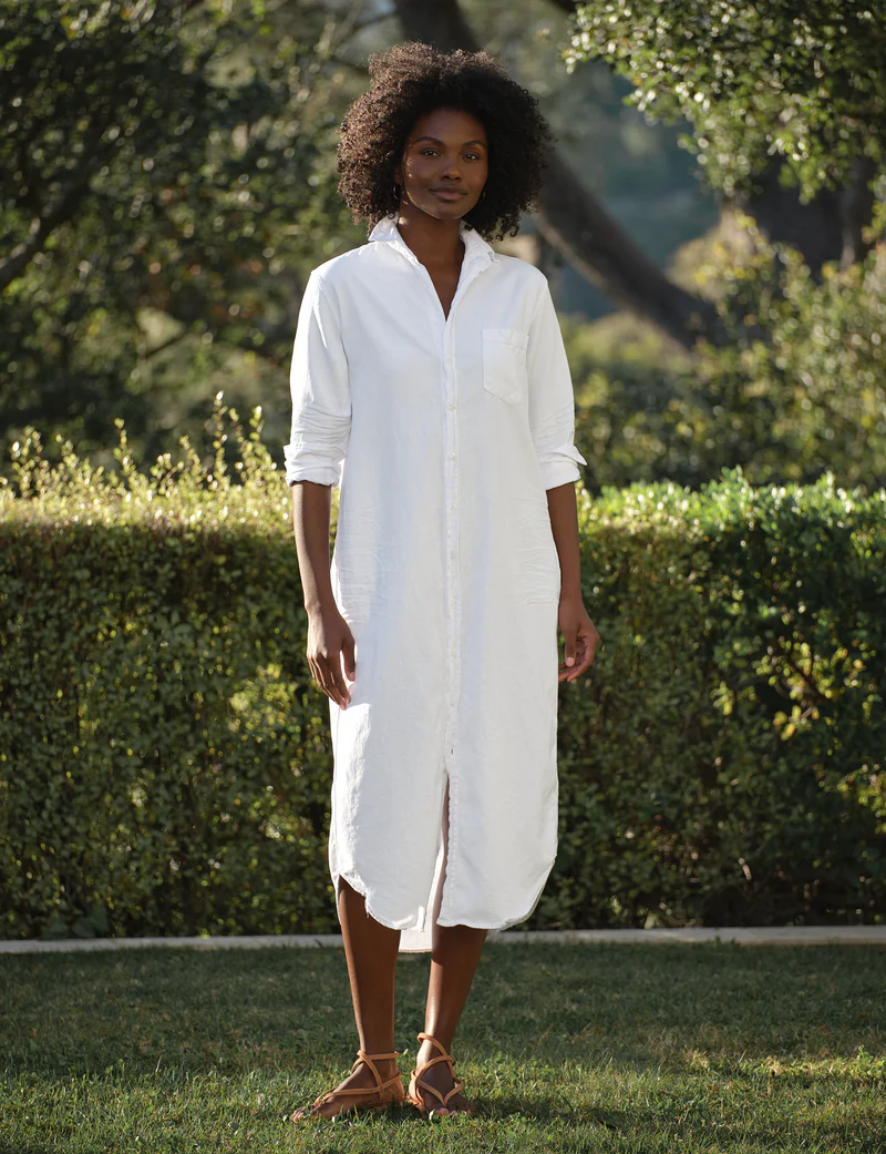 woman wearing a white maxi shirtdress in a garden