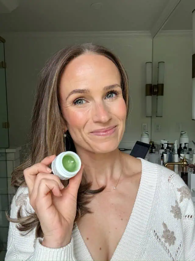 Woman holding Oliveda lip balm