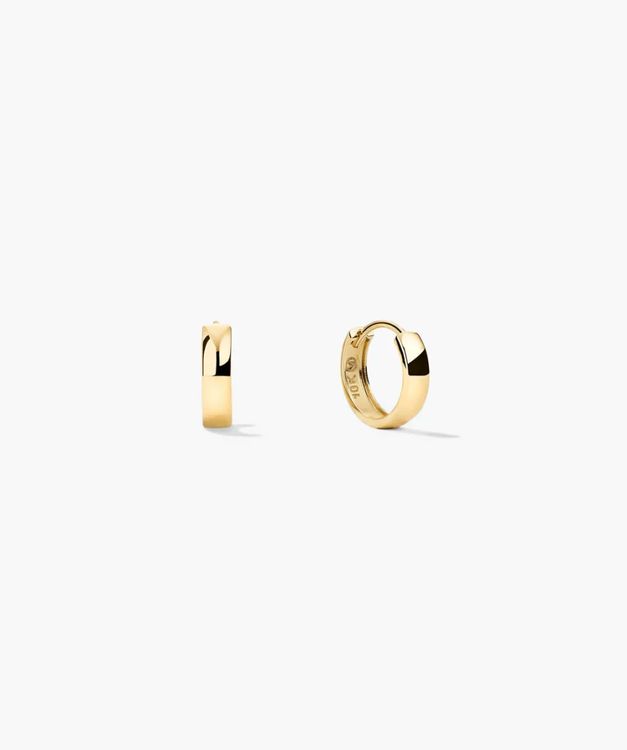 Mejuri Bold Huggie Hoops in 10k gold with wide smooth polished band, Mejuri 10k stamp visible