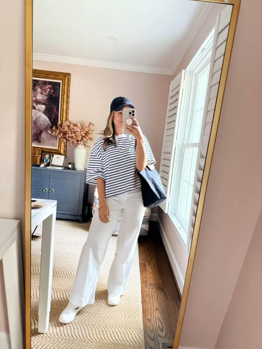 Woman styling linen pants with striped tee and ball cap
