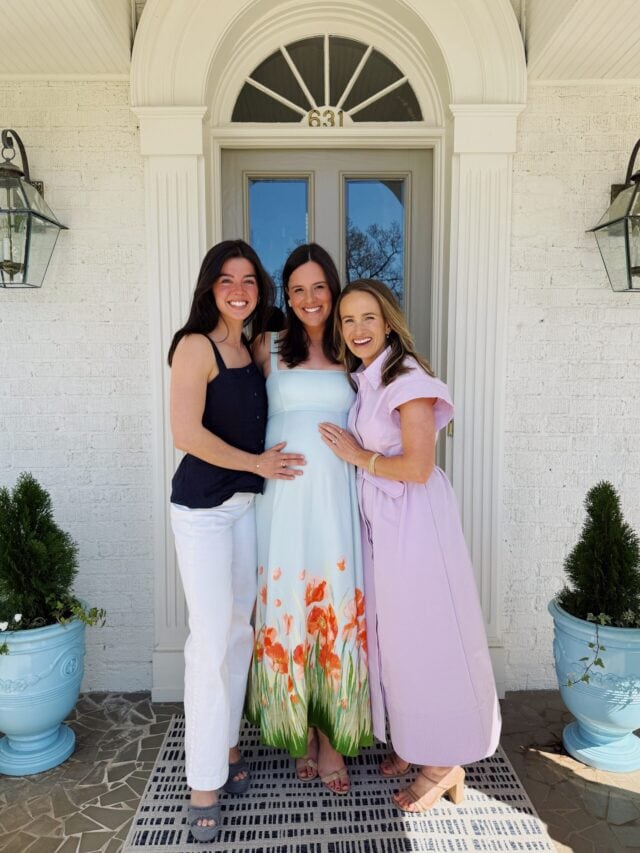 Two women wearing long dresses posing with pregnant woman