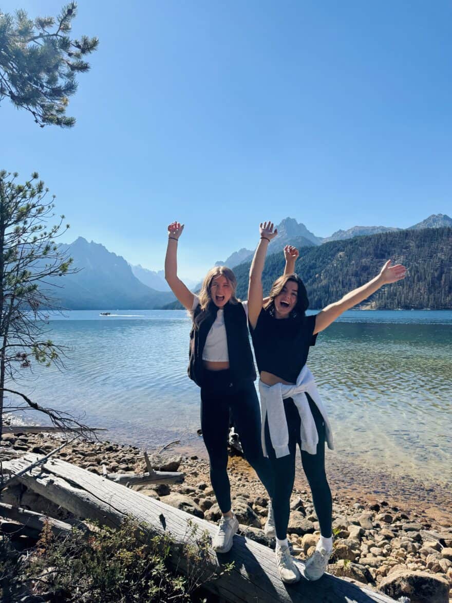 Two women standing beside water in athleisure
