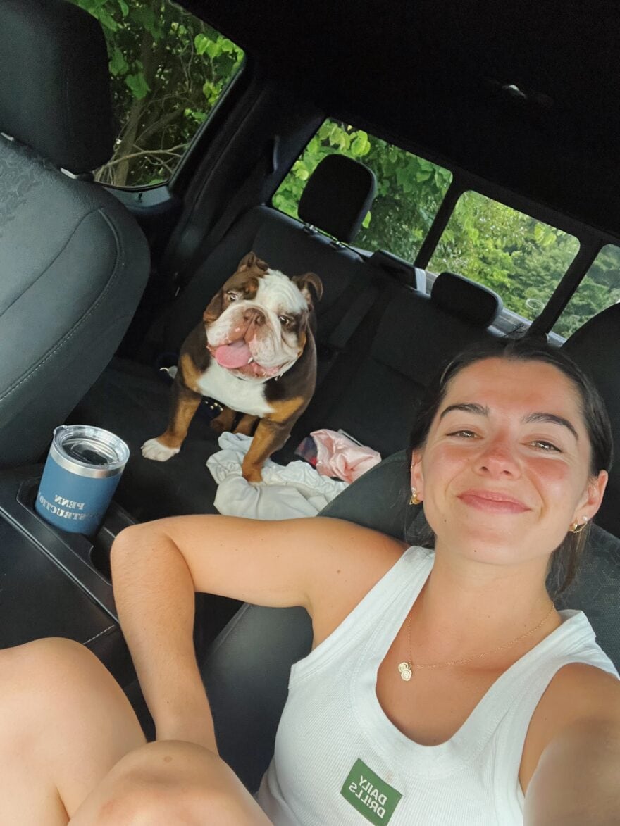 Woman sitting in car with dog