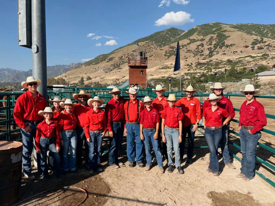 Women and men wearing red tops and denim and cowboy hats