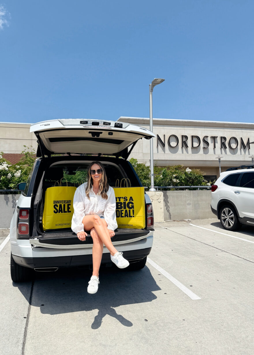 TeriLyn Adams sitting in the back of her car with Nordstrom Anniversary Sale bags