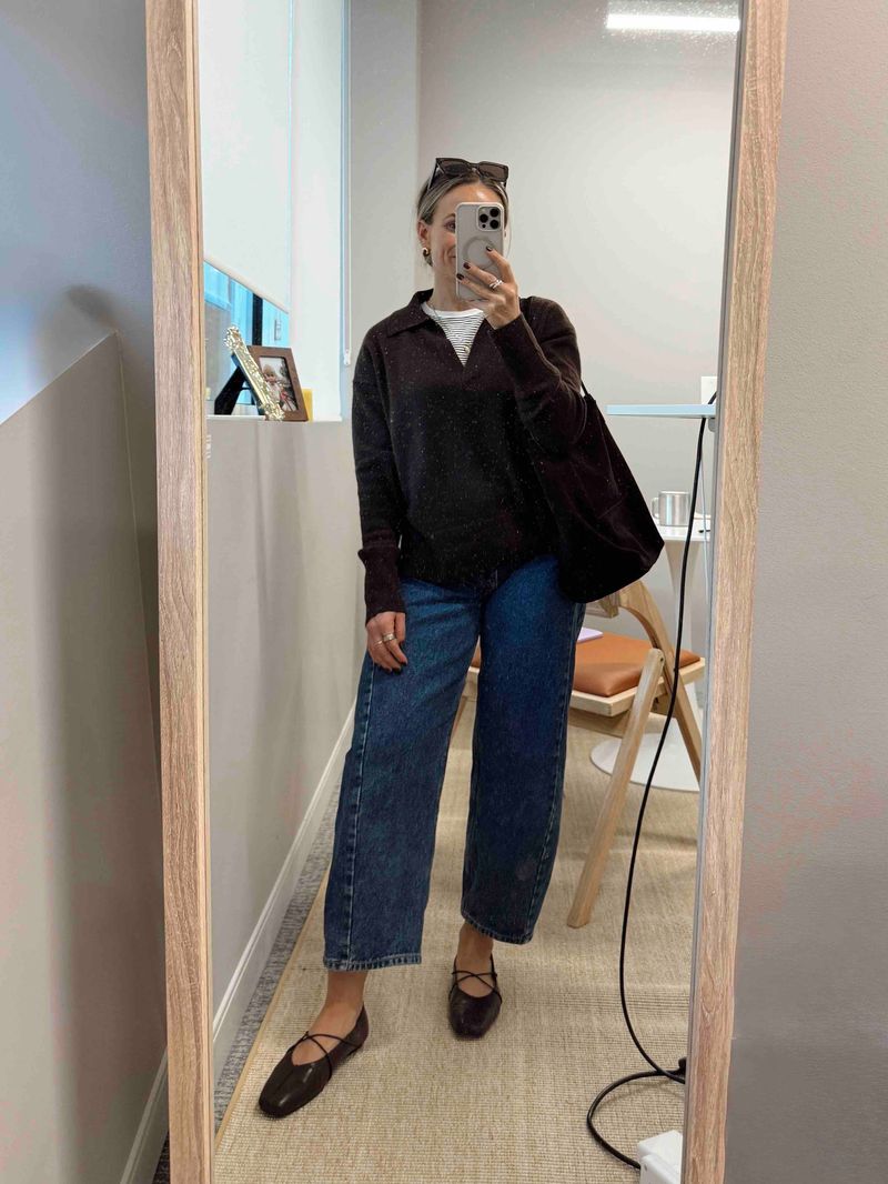 TeriLyn Adams wearing a black collared sweater, dark wash barrel jeans, and black ballet flats