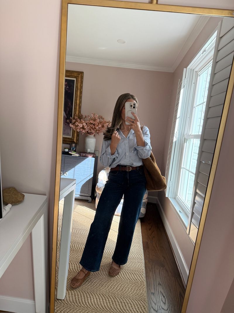 TeriLyn Adams wearing a blue button-down tucked into dark wide-leg jeans with woven flats