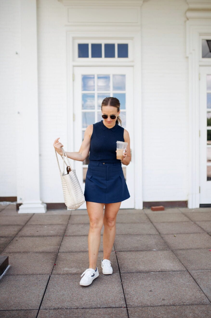Woman wearing navy skort with handbag