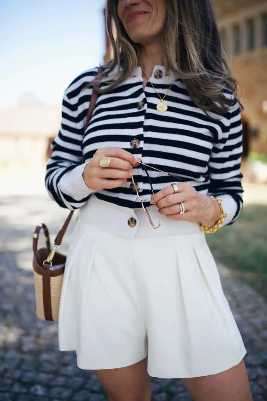 Woman wearing cardigan and white shorts