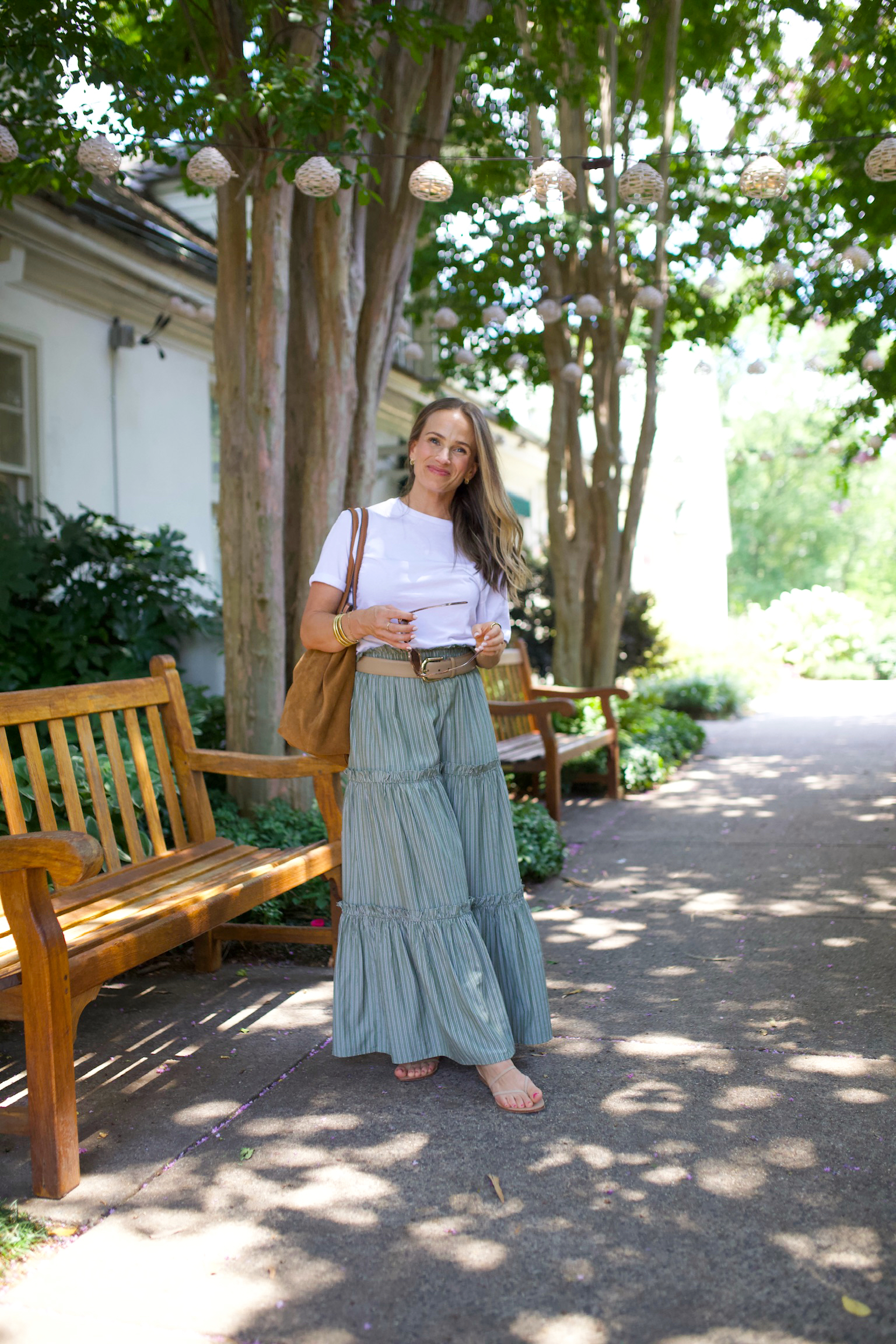 TeriLyn Adams wearing a white t-shirt tucked into a green striped maxi skirt with a leather belt