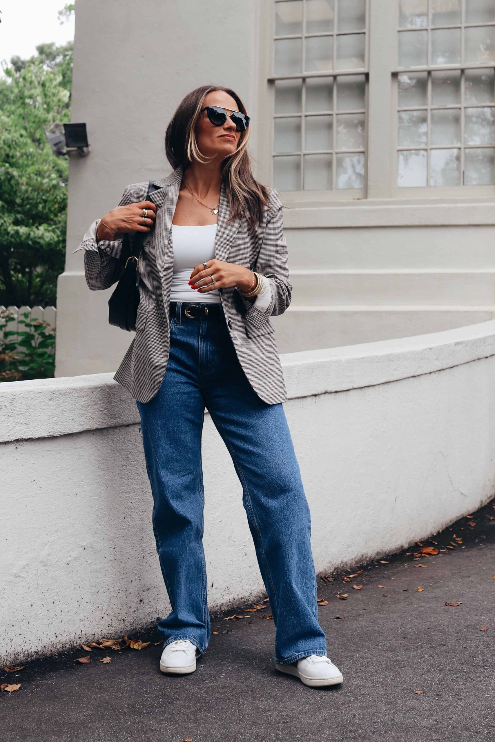 woman standing in abercrombie 90s high rise 90s jeans with blazer and sunglasses 