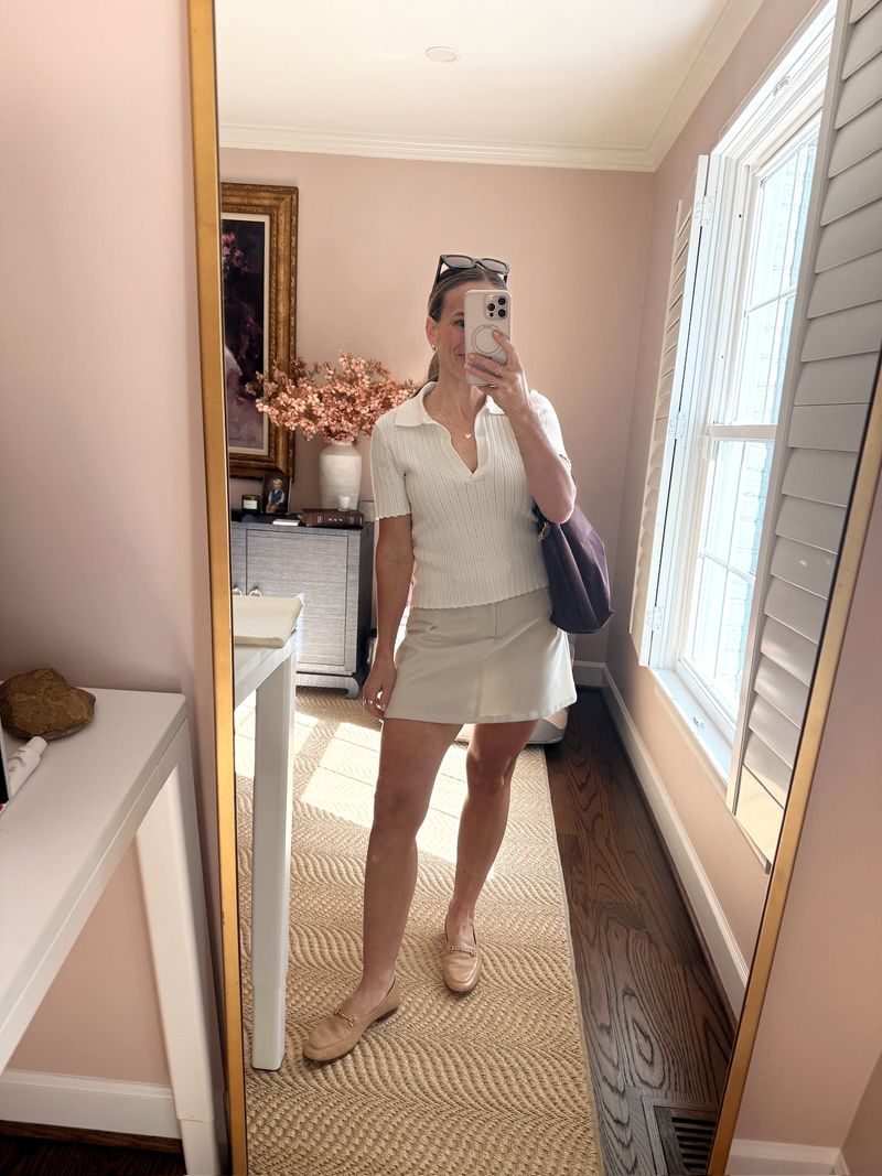 TeriLyn Adams wearing a white polo, cream skort, and tan Sam Edelman Loraine loafers