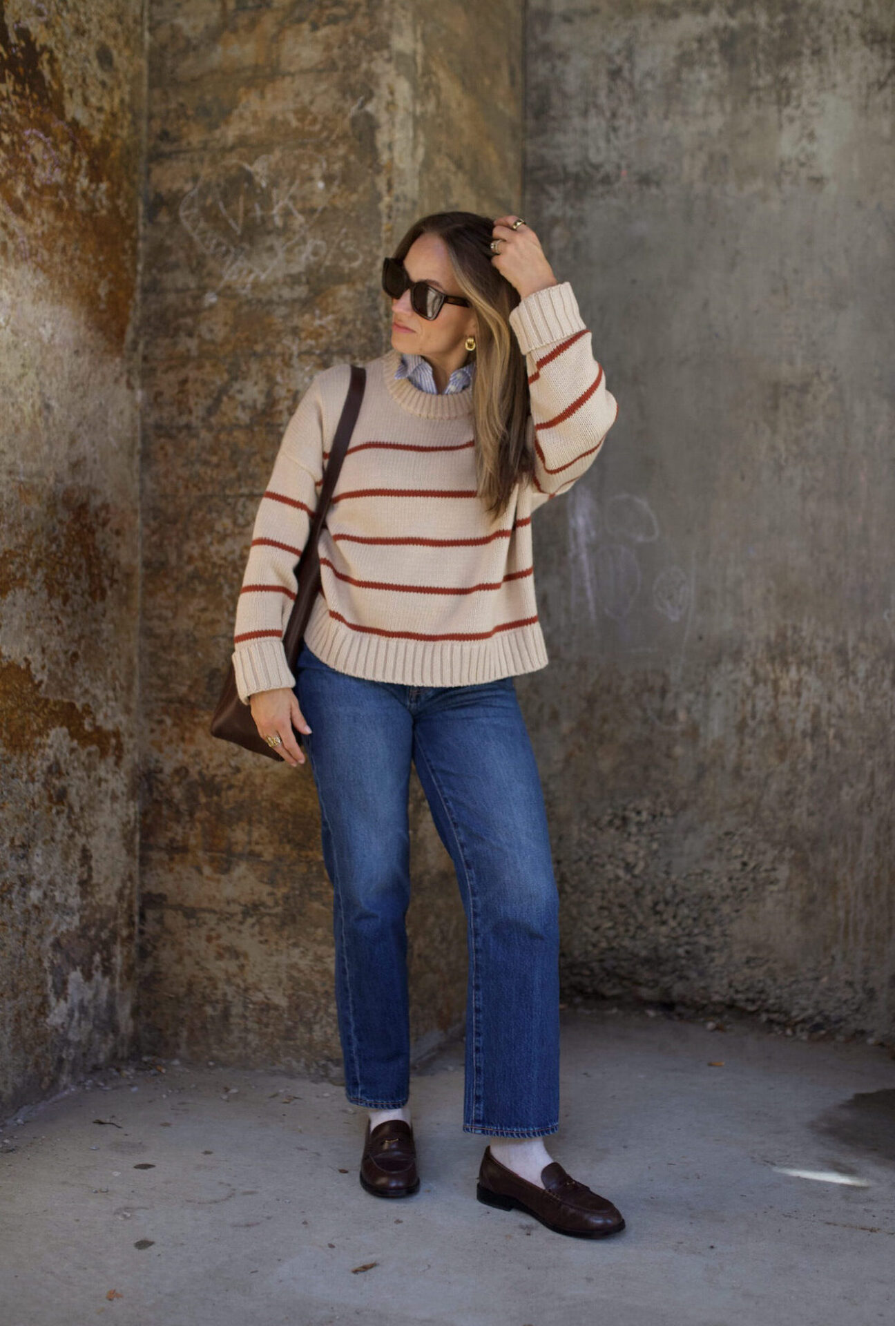 TeriLyn Adams wearing a striped sweater, straight-leg jeans, and brown loafers