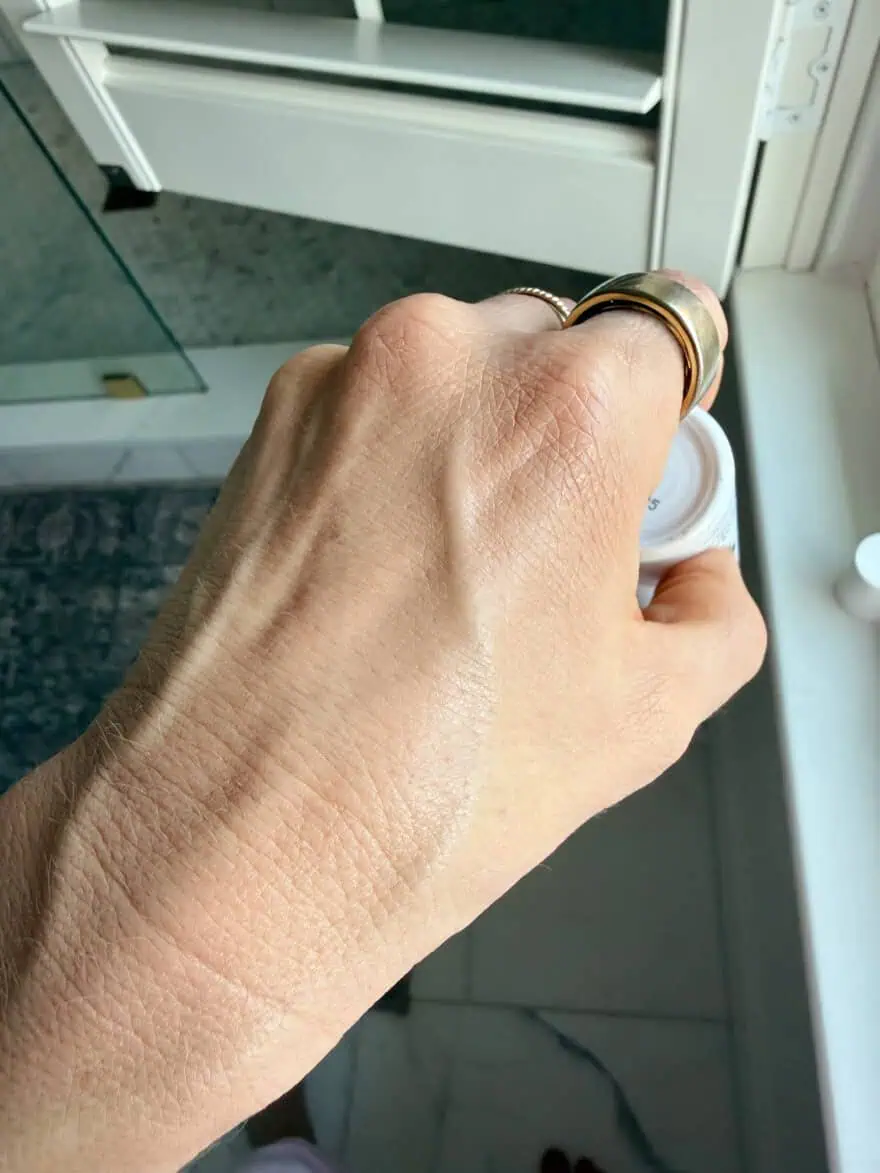 Woman showing hand after blending a drop of Olive Rose skin tint